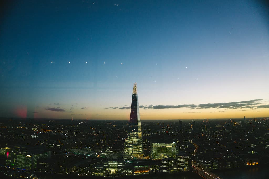 London at blue hour, the Shard rising over the lit city.