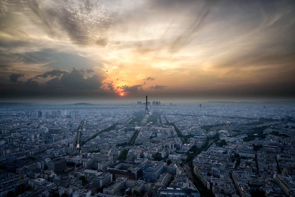 Paris at sunset from above, the Eiffel Tower against a low sun.