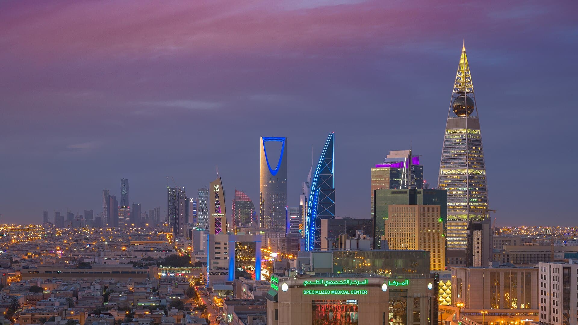 Riyadh at twilight, the Kingdom Centre and Al Faisaliah against a violet sky.